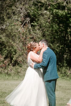 A couple shares their first kiss as newlyweds during an outdoor garden wedding ceremony. Hayne, Devon