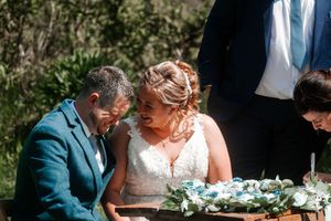 A couple shares a tender moment during their outdoor wedding ceremony. Hayne, Devon