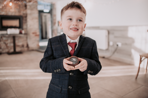 A collage of six photos showing a young boy in a dark suit and red tie posing in different positions and expressions.