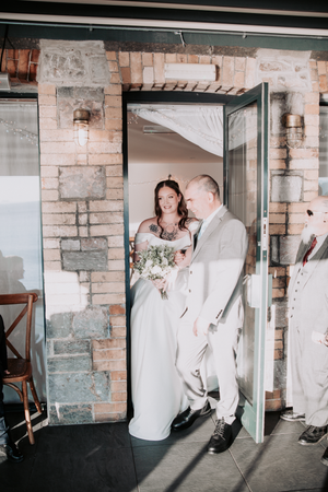 A romantic couple shares intimate moments in a stone-walled room during a wedding photoshoot.