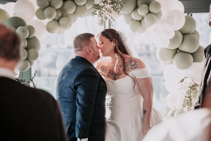 Romantic wedding couple shares intimate moments under elegant white balloon decorations at their reception celebration.