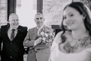 A series of candid black and white wedding photos showing joyful laughter and celebration at a reception.