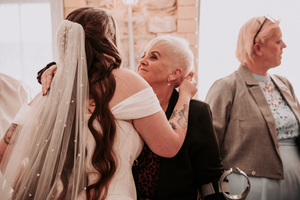 People gathered in a warm-toned setting helping with wedding preparations.