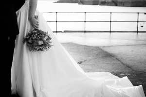 A black and white film strip showing seven sequential frames of a wedding ceremony in progress.