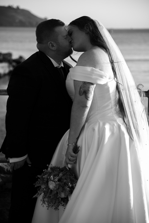 Black and white wedding portraits showing intimate moments between newlyweds in elegant attire.