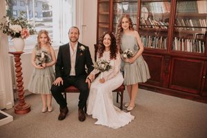 Wedding party gathered in a traditional library setting with wooden furnishings.