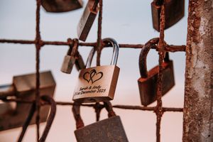 Close-up view of rusty love locks attached to metal fence or bridge railing.