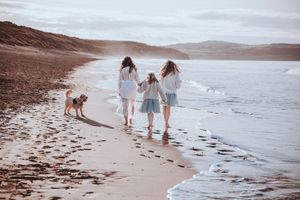 Mother and Daughters and Golden Doodle walking along the sand in Hayle, Cornwall