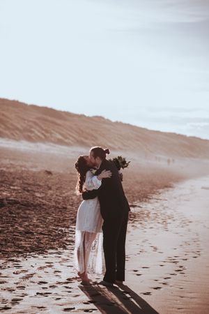 A tender moment captured between a couple on a beach at sunset with long shadows. Editorial Couples Portraits in Godrevy Cornwall.