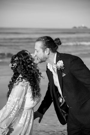 A black and white intimate moment between newlyweds on a windswept beach in Cornwall.