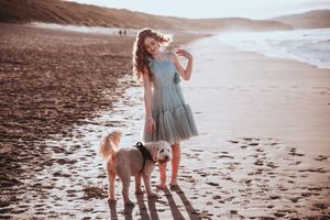 Family enjoying a sunset stroll along a sandy beach with soft warm lighting. Cornwall