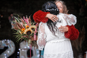 Wedding celebration with white lace dress and colorful floral bouquets.