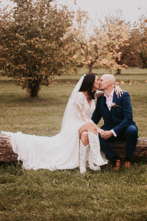 Romantic outdoor wedding photos of couple sitting on grass during golden hour.Over Barn, Gloucester,
