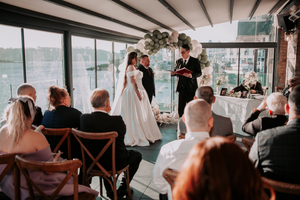 Wedding reception venue with guests seated at tables under wooden beams.Pier One, Plymouth, Devon.
