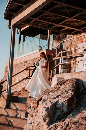 Wedding photography at stone building with dramatic coastal backdrop.
