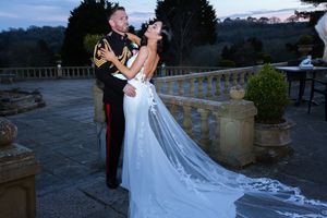 Wedding couple poses on stone terrace with dramatic mountain backdrop.Elfordleigh, Plymouth Devon
