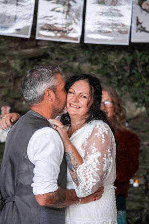Romantic wedding moment captured against a rustic stone wall backdrop. Porthcew Dairy, Porthleven,