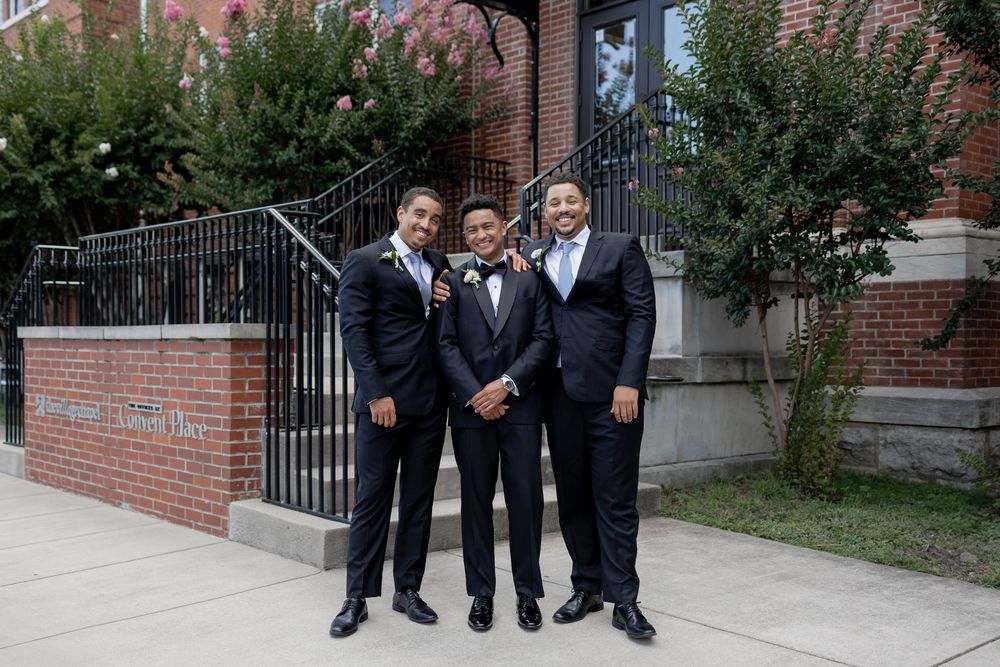 Three people in formal black tuxedos pose together on brick steps outside a building. NASHVILLE WEDDING PHOTOGRAPHER