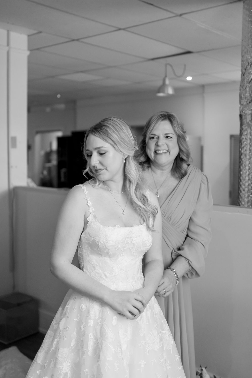 People getting ready in a bright room wearing formal attire for a wedding celebration. NASHVILLE WEDDING PHOTOGRAPHER