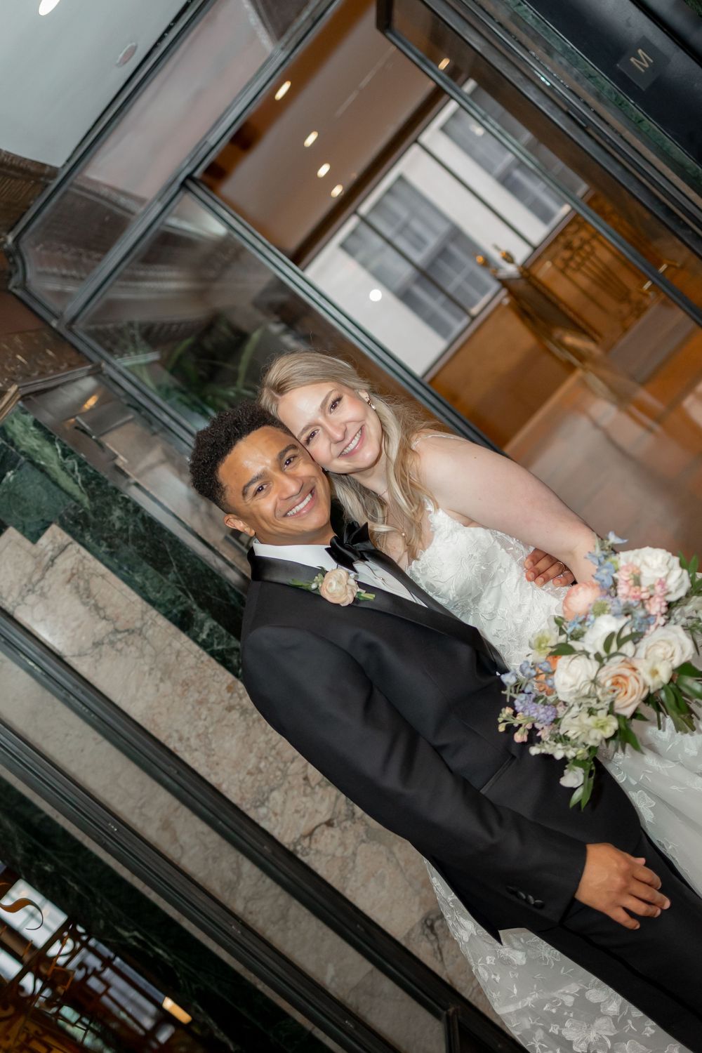 A couple posing together in formal wedding attire in an indoor venue.  NOELLE NASHVILLE WEDDING PHOTOGRAPHER