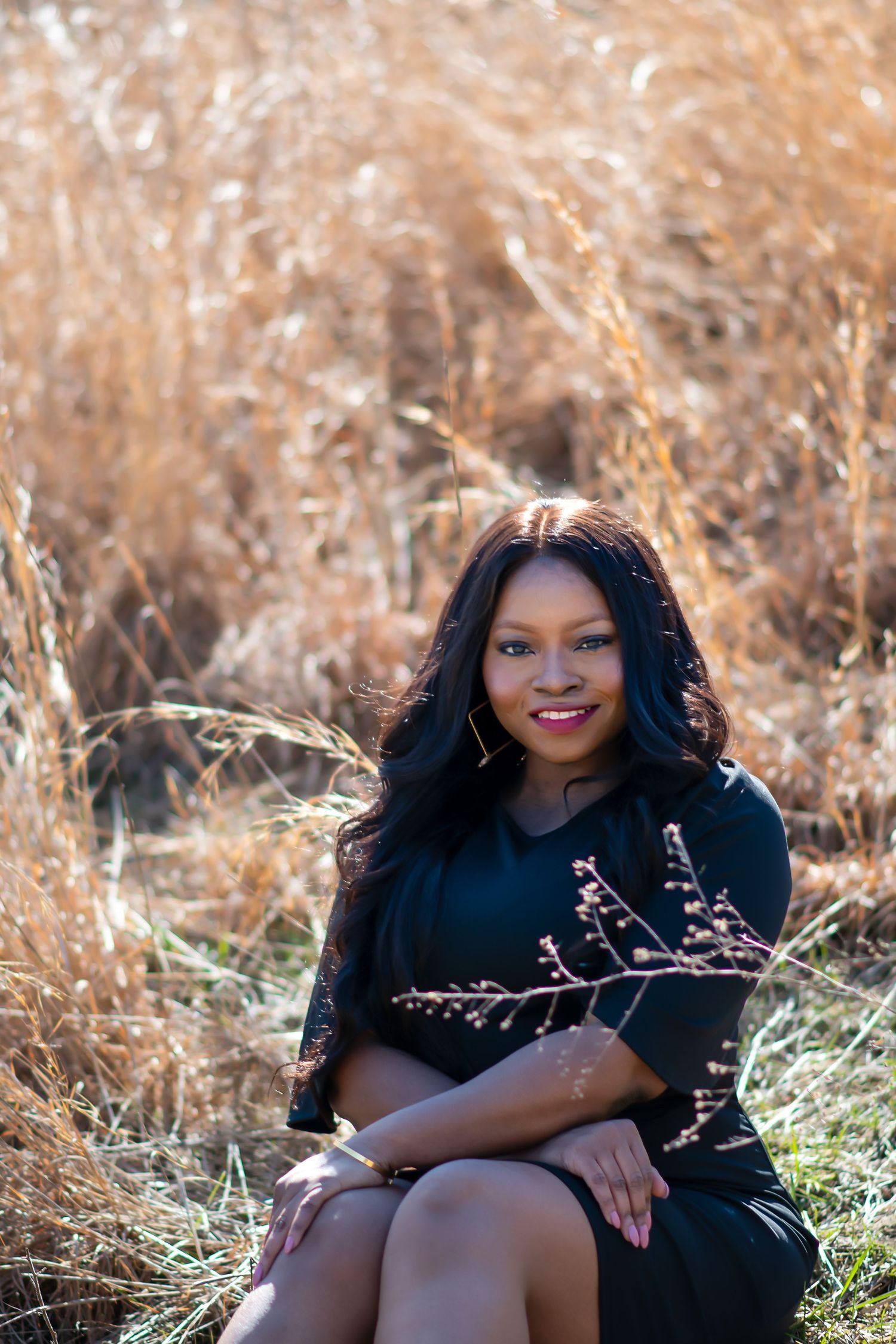 Outdoor portrait in golden field with dried plants and warm autumn tones.