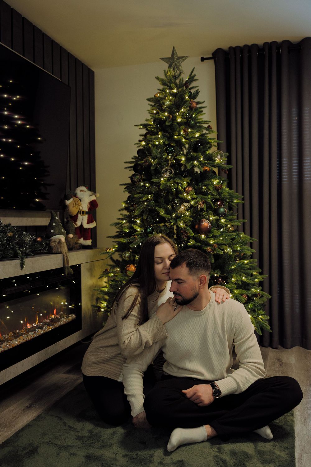 A cozy Christmas scene with a decorated tree and soft lighting creates a warm holiday atmosphere in a living room.
