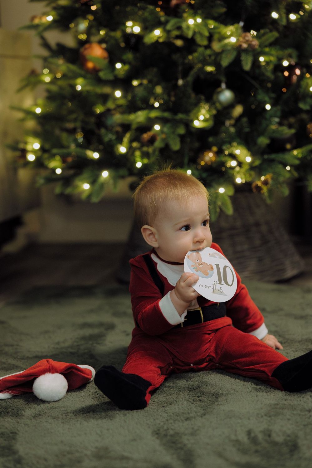 A festive scene shows movement across green carpet under a lit Christmas tree with twinkling lights.