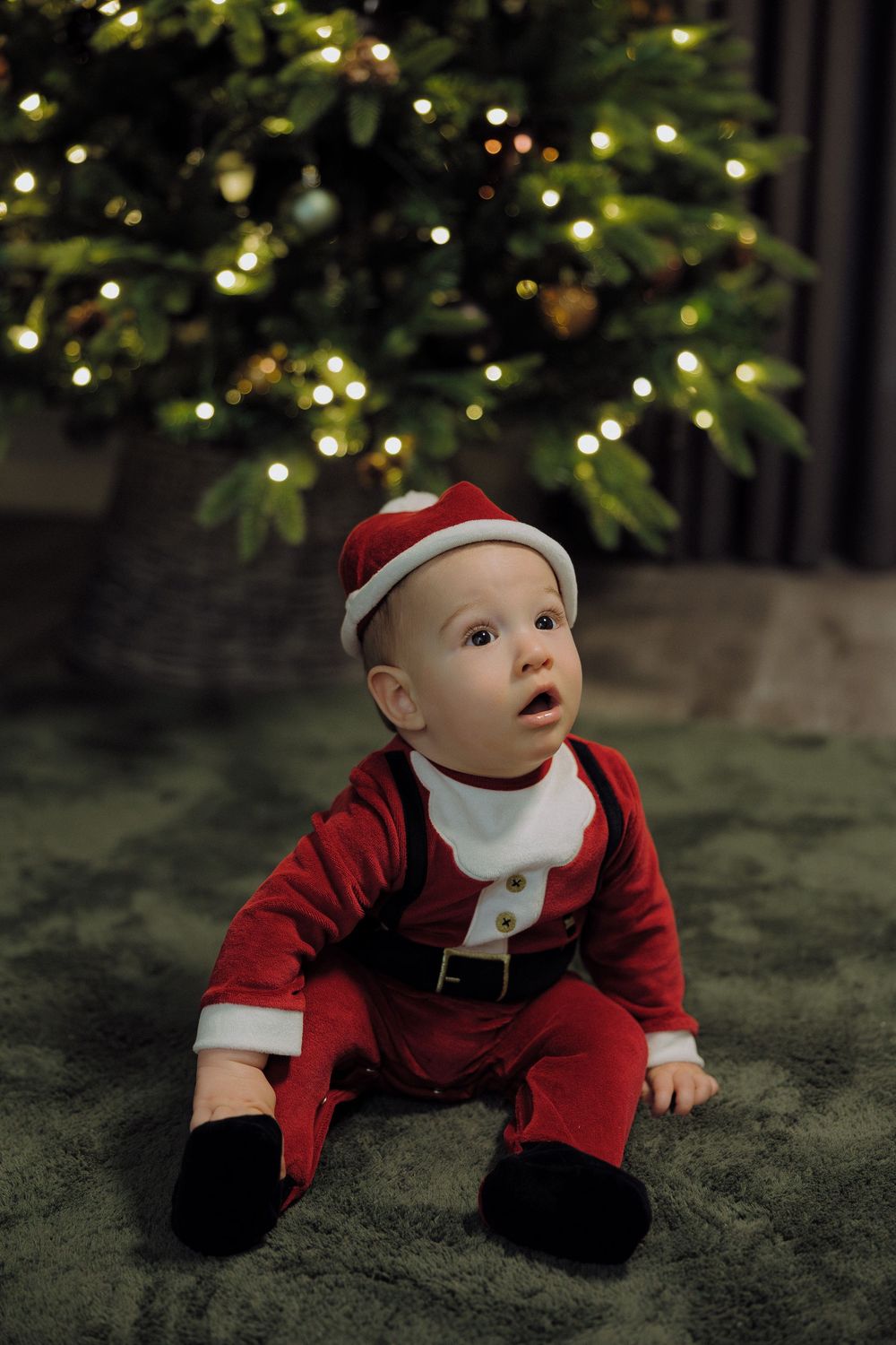 A holiday-themed photo sequence captured under a sparkling Christmas tree with green carpet below.