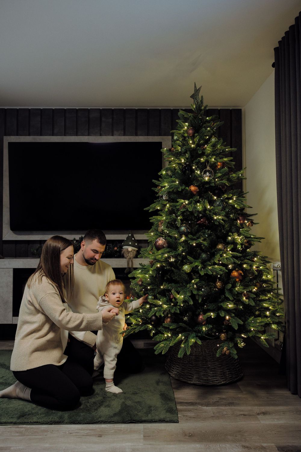 A heartwarming sequence of holiday moments shows a parent and baby sitting in front of a decorated Christmas tree.
