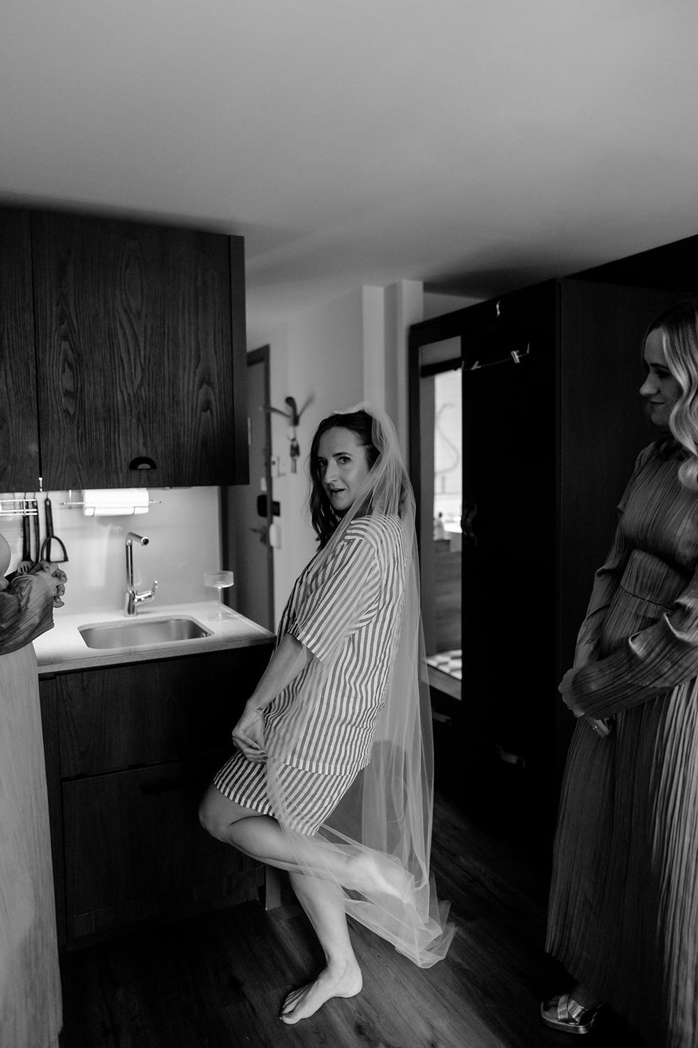 Interior scene with people in striped dresses moving through a minimalist space.