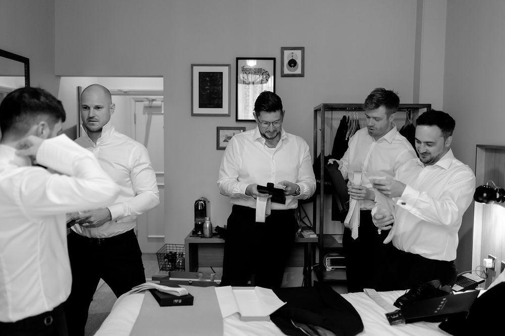 Group of people in white shirts laughing and socializing in a room.