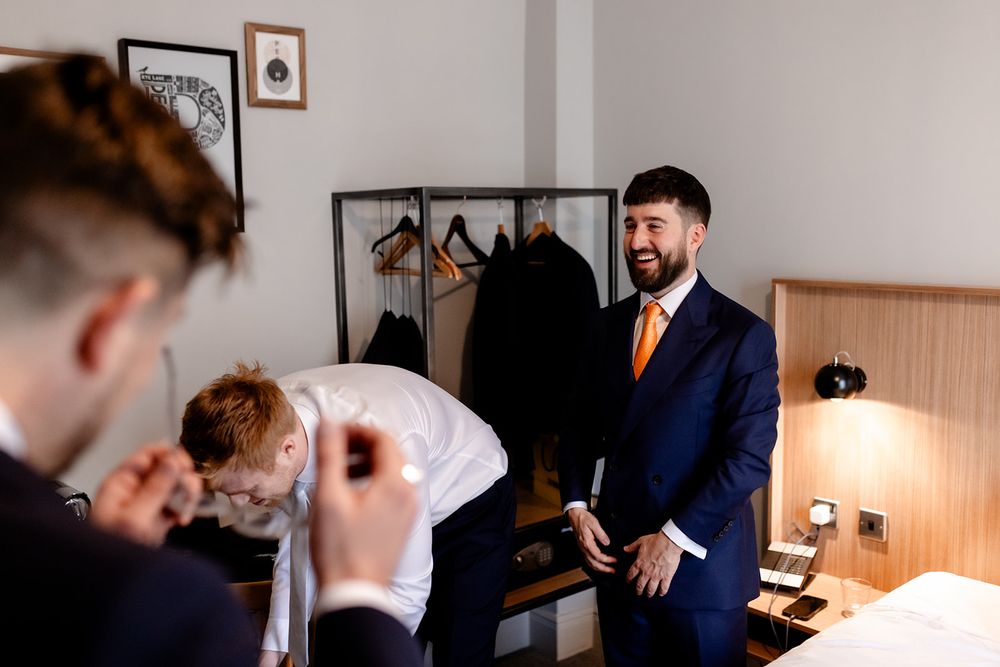 People in formal attire interacting and laughing in a well-lit room.