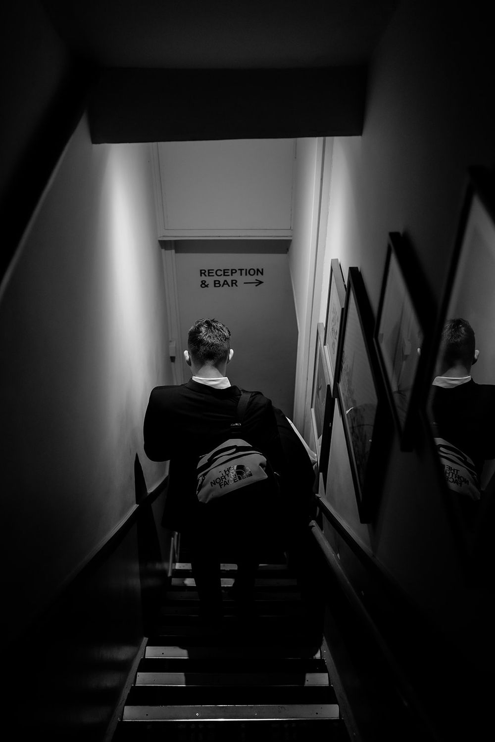 Dark hallway with directional signs pointing to reception and bar areas.