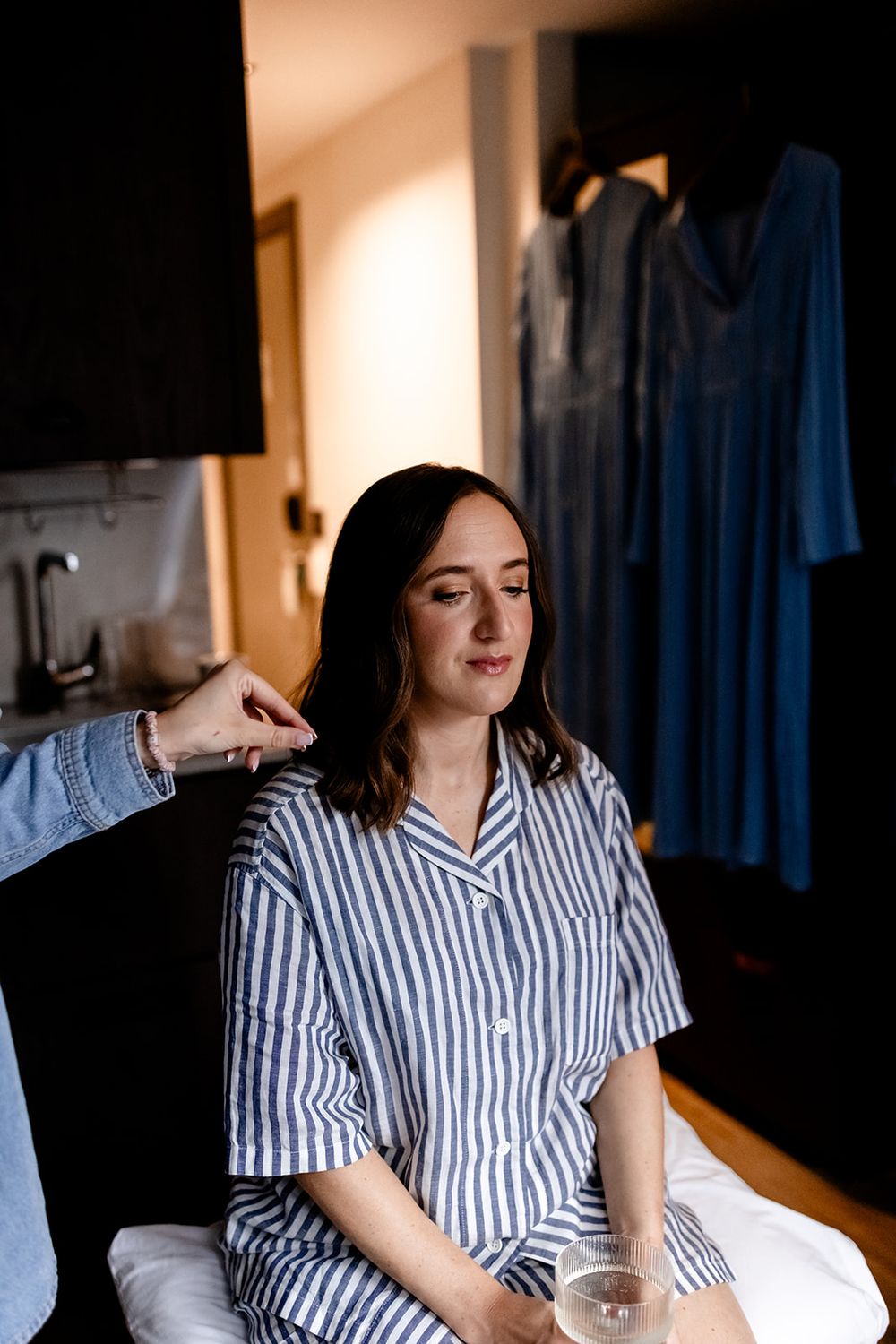Person in striped pajamas relaxing in a dimly lit room.