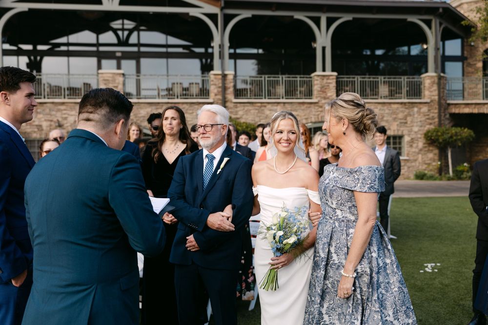 Elegant outdoor wedding ceremony setup with stone architecture and floral decorations.