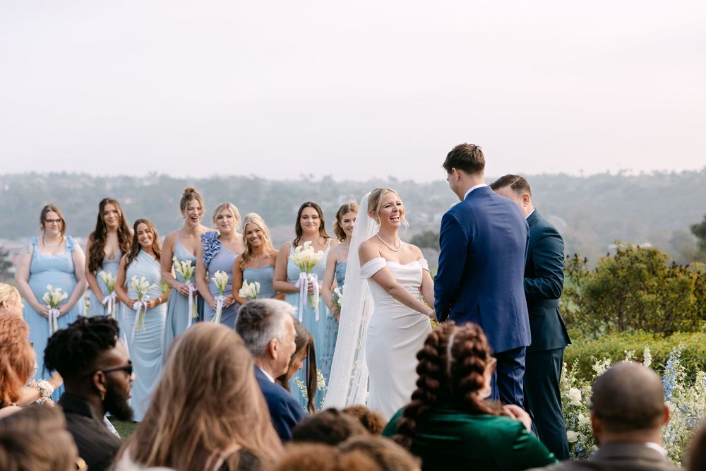 Panoramic view of wedding guests seated for an outdoor hilltop ceremony.