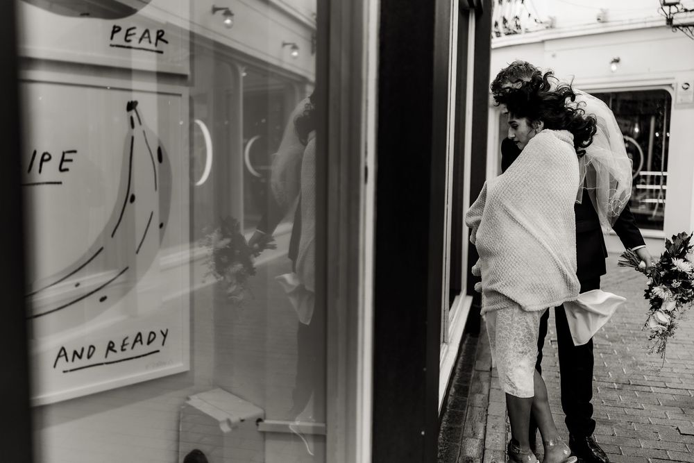 Black and white photograph of a storefront window with text and reflections.