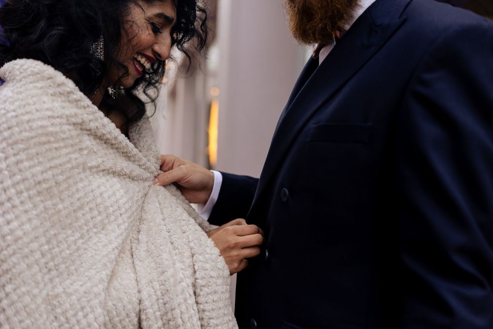 A couple in wedding attire share a tender moment during their winter celebration.