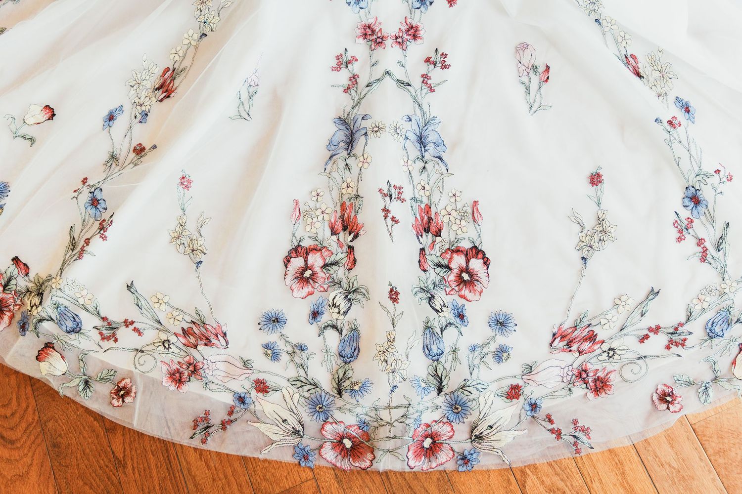 Close-up detail of floral pattern on white wedding dress fabric.