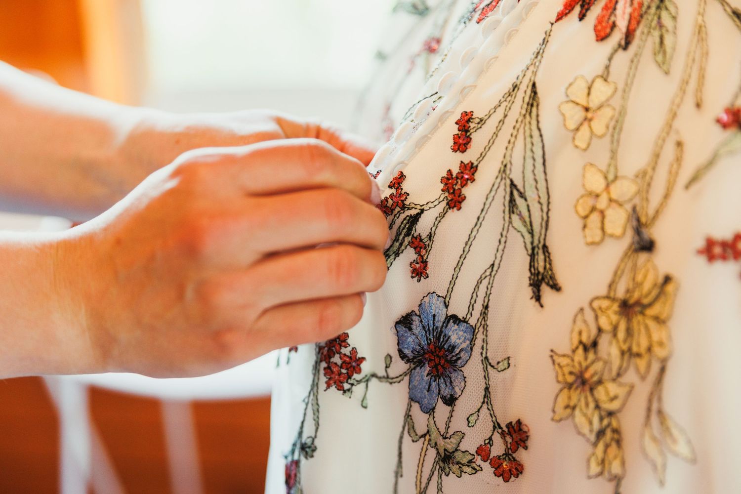 Close-up of intricate floral embroidery details on wedding dress bodice.