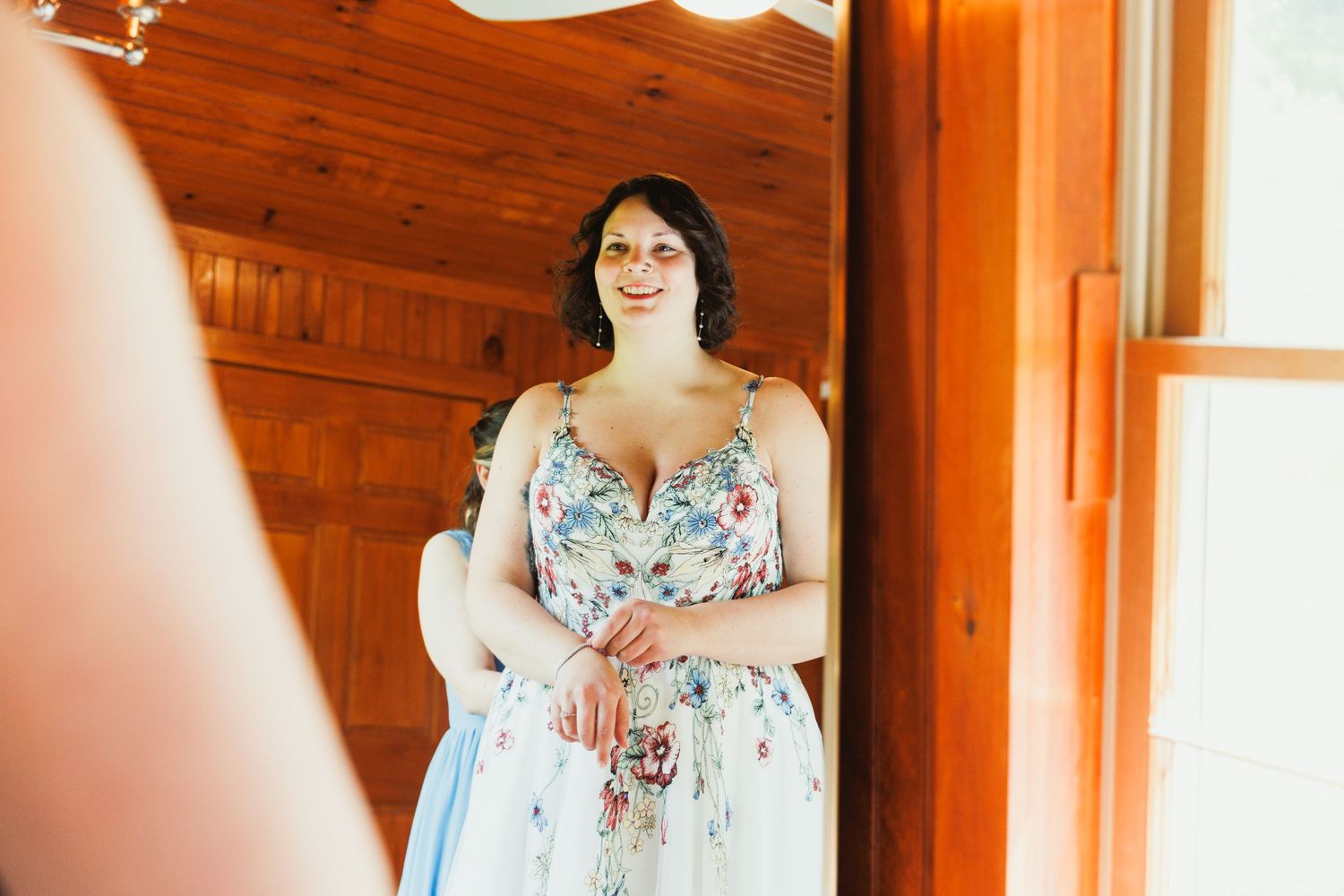 Wedding dress fitting session showing floral pattern details in warm lighting.