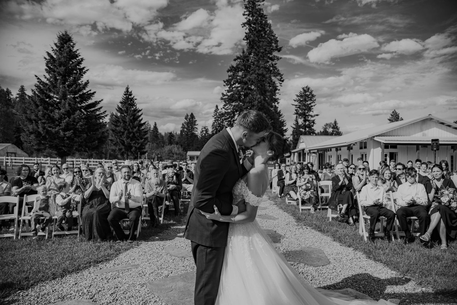 Black and white wedding ceremony montage showing outdoor celebration moments with guests and couples under cloudy skies.