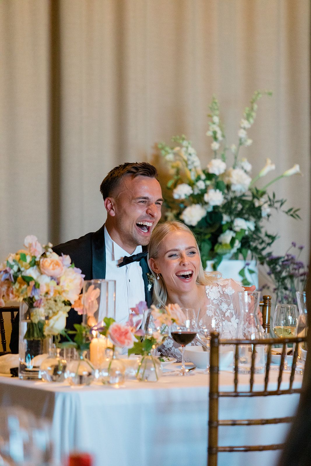 Wedding guests dancing and celebrating with raised arms at a lively black and white reception party.