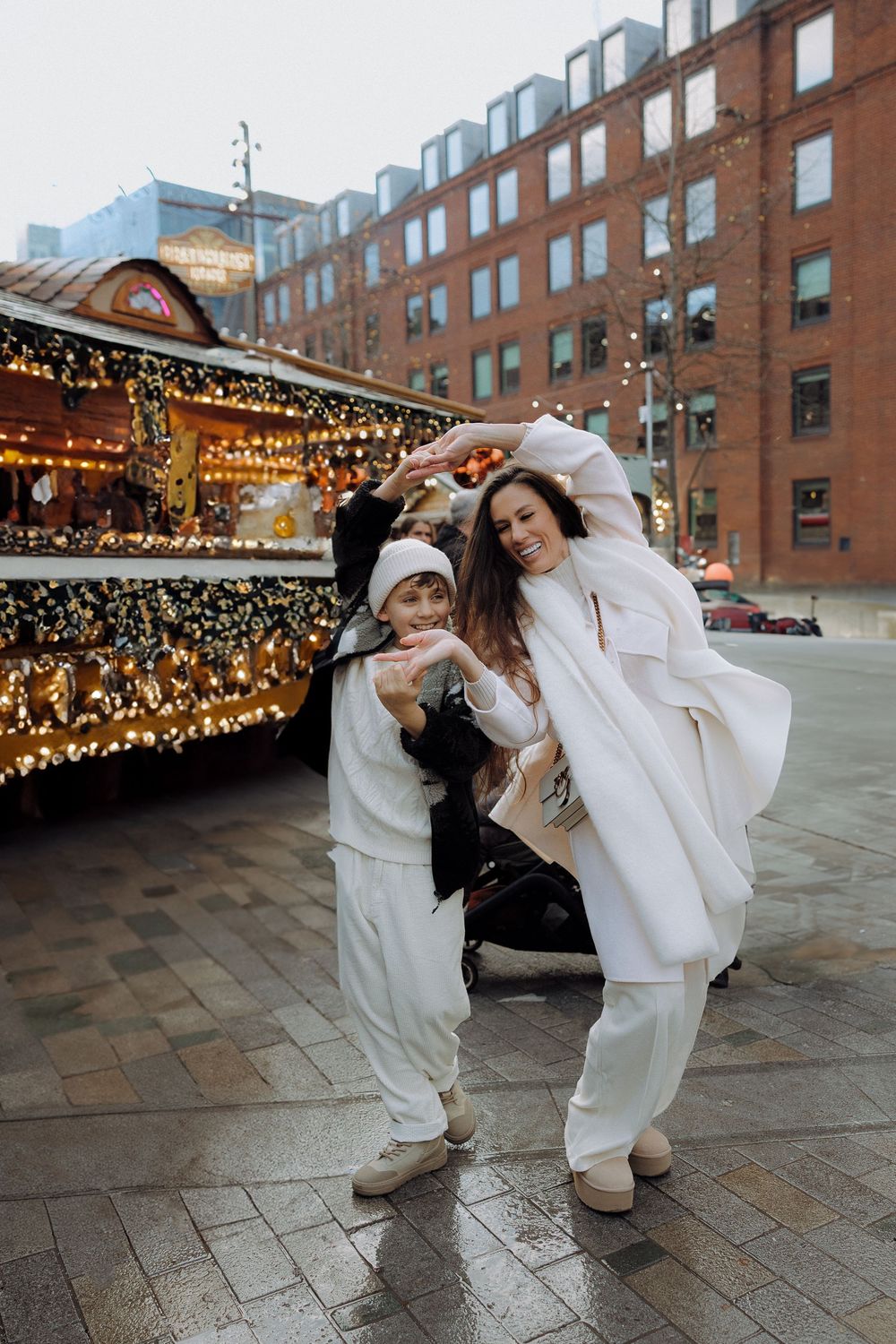 Playful dance moves performed on brick pavement with string lights in the background.