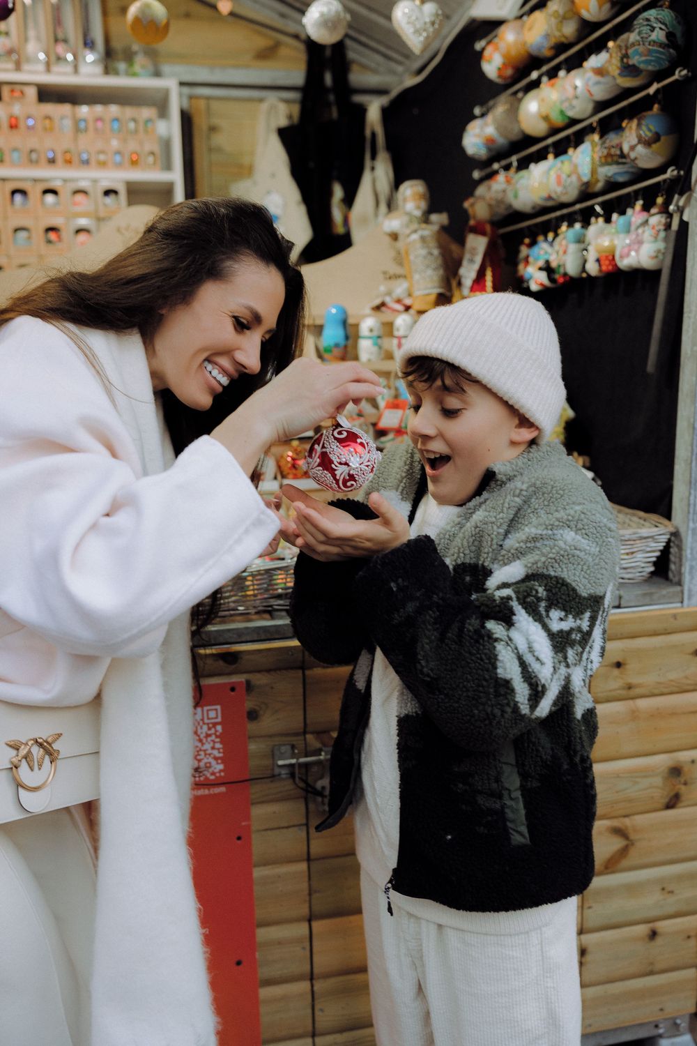 Candid moments captured at a Christmas market with wooden stalls and festive decorations.