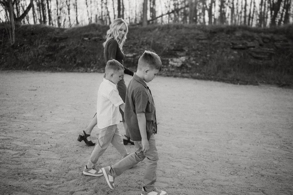 Two young children playing and laughing together on a dirt path in a black and white photograph.