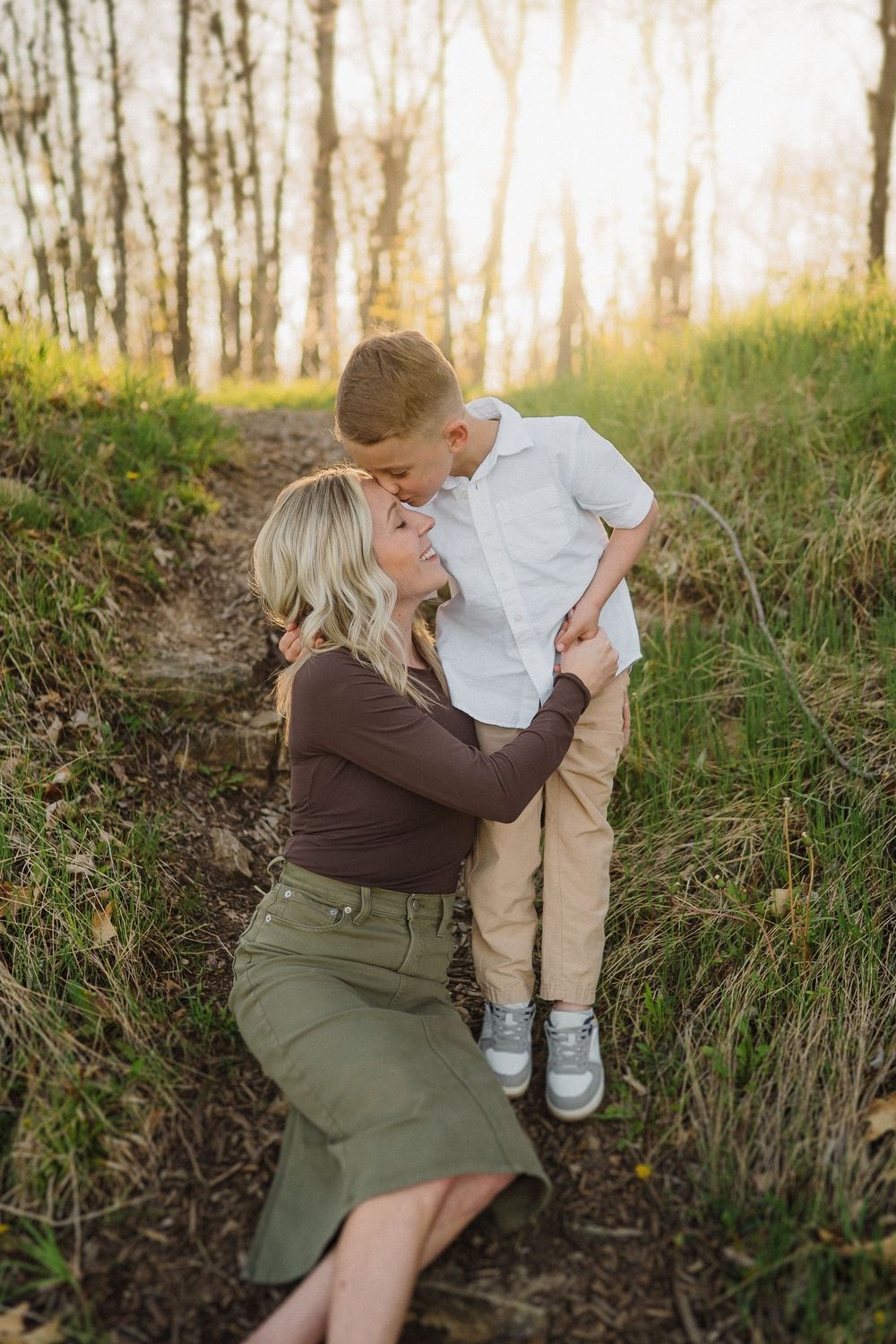 Tender moment between parent and child on a nature path during golden hour.