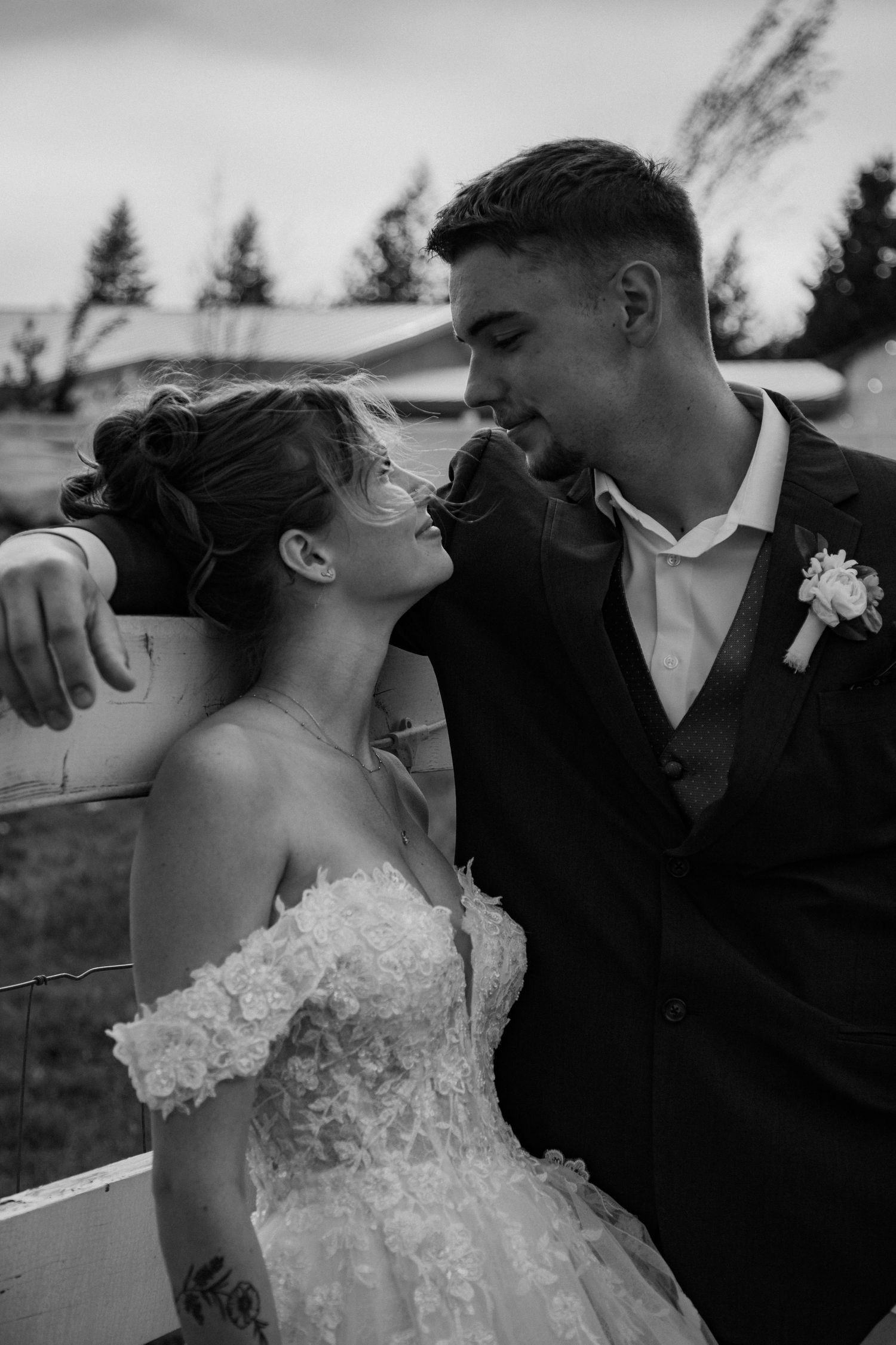 A black and white wedding ceremony moment showing a couple sharing a joyful exchange at their outdoor forest wedding.