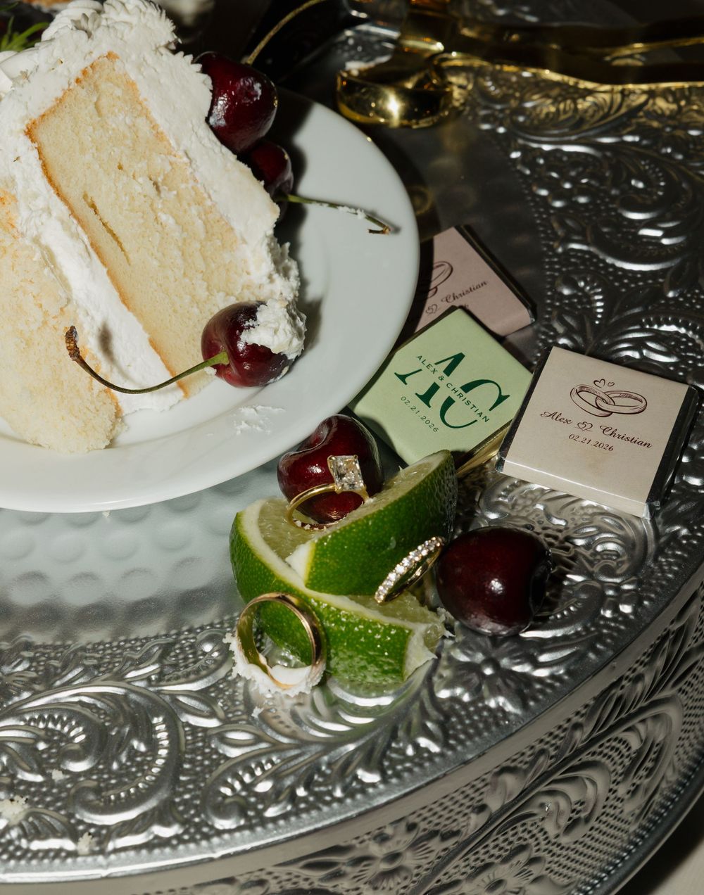 Elegant dessert plate with cherries and lime garnish on an ornate silver platter.