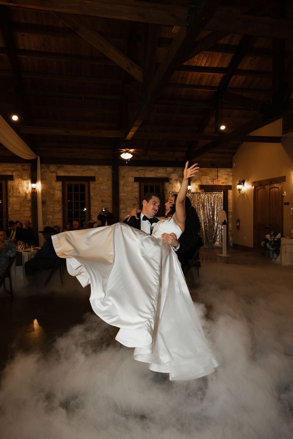 Smoke filled dance floor with performers in white flowing costumes creating dramatic atmosphere.